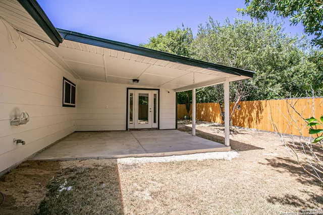 a backyard of a house with table and chairs