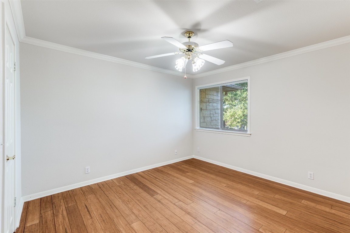 6901 Bright Star Lane Austin, TX 78736 - Photo 20 of 24 an empty room with wooden floor chandelier fan and windows
