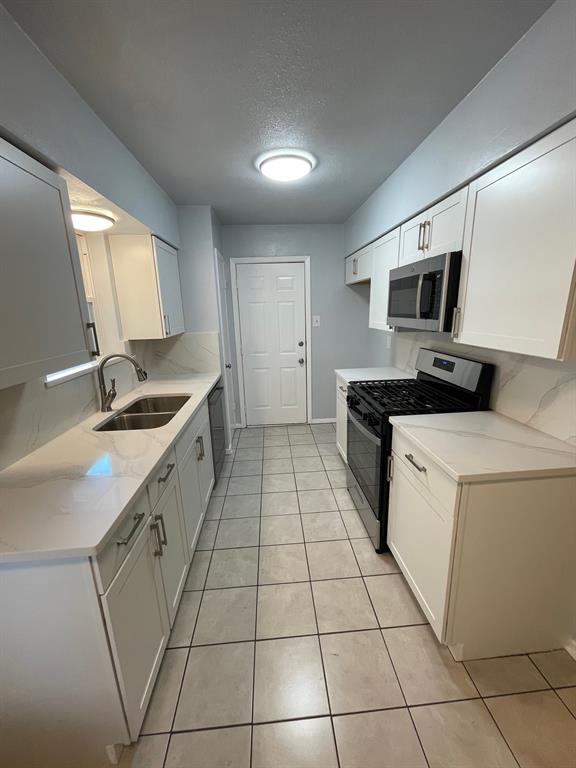 738 East Oates Road Garland, TX 75043 - Photo 6 of 19 a kitchen with a sink a stove and cabinets