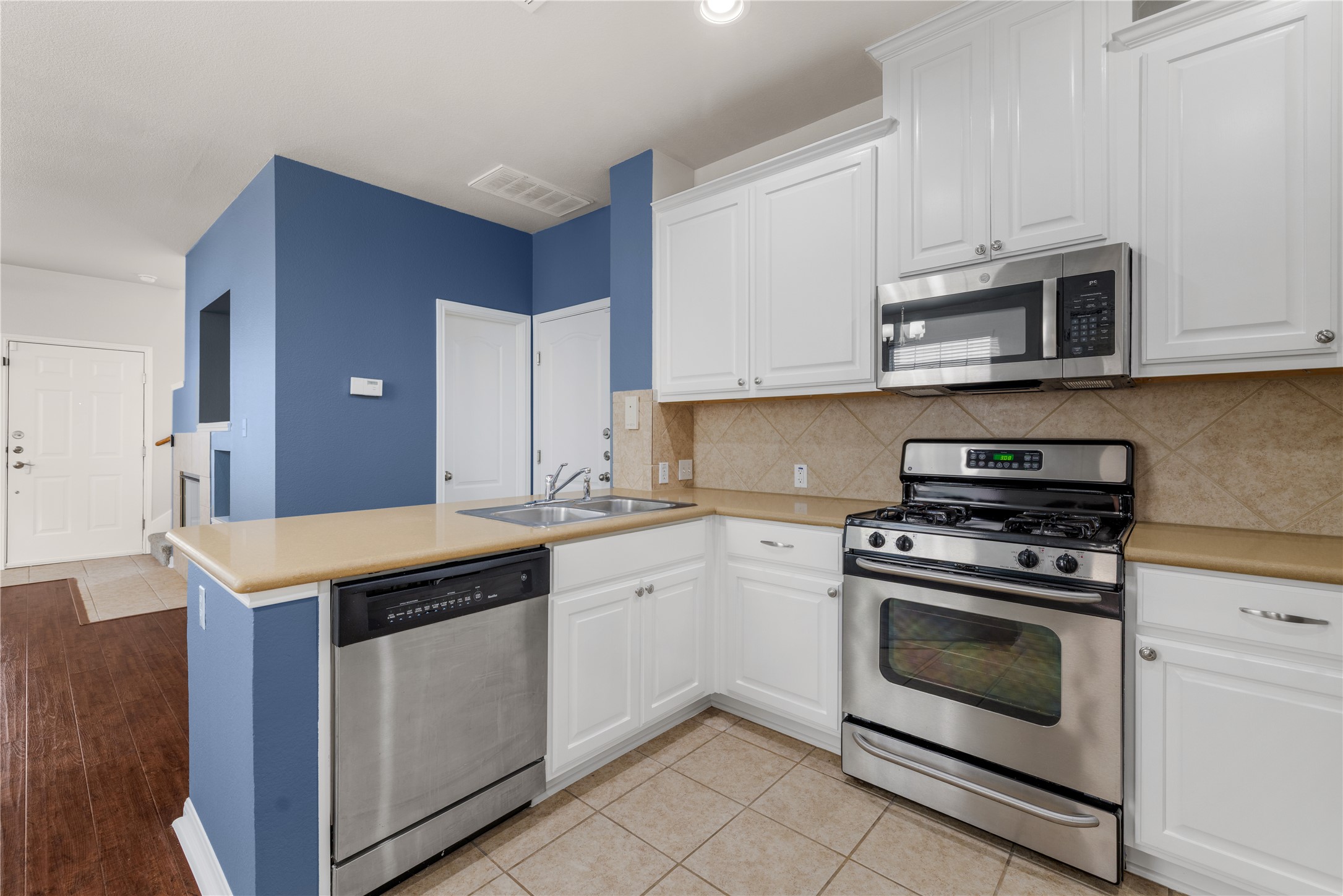 11000 Anderson Mill Road, Unit 45 Austin, TX 78750 - Photo 12 of 32 a kitchen with granite countertop a stove top oven microwave and cabinets