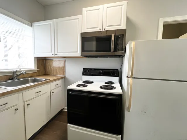 a kitchen with a white stove top oven and refrigerator