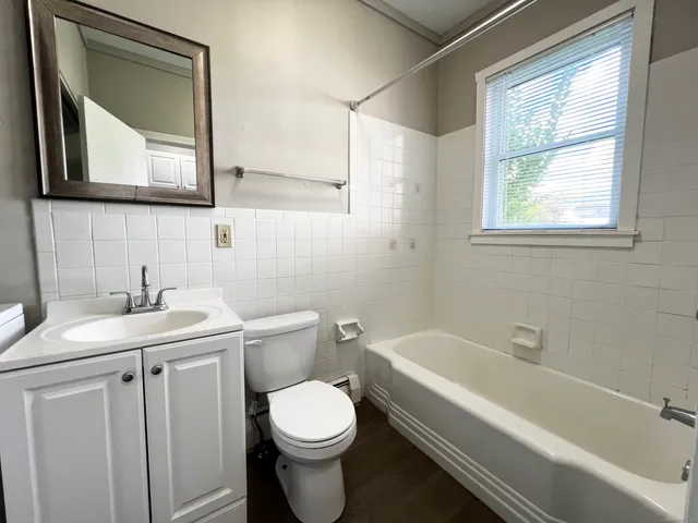 a bathroom with a toilet a sink a mirror and a bathtub