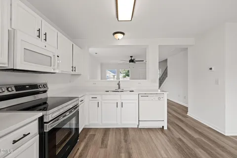 a large kitchen with stainless steel appliances granite countertop a stove a sink and a refrigerator