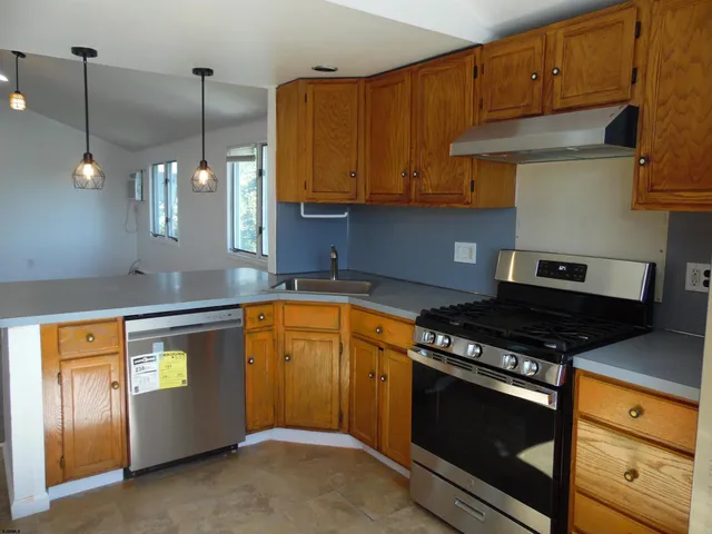 a kitchen with stainless steel appliances a refrigerator a stove a sink and a counter space