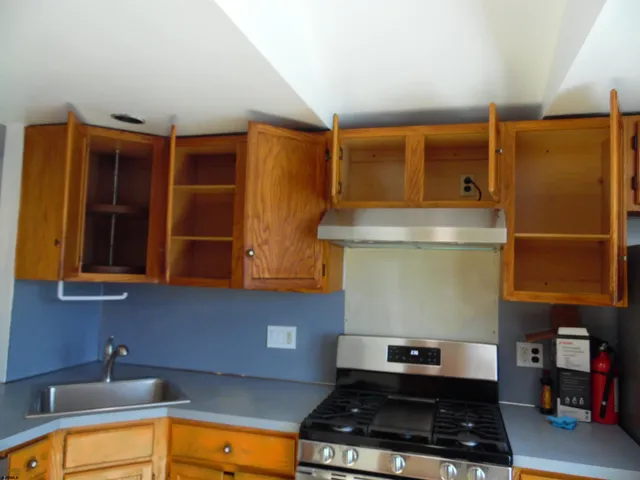 a kitchen with stainless steel appliances granite countertop a sink a stove and a refrigerator