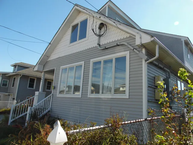 a view of a house with a small yard and potted plants