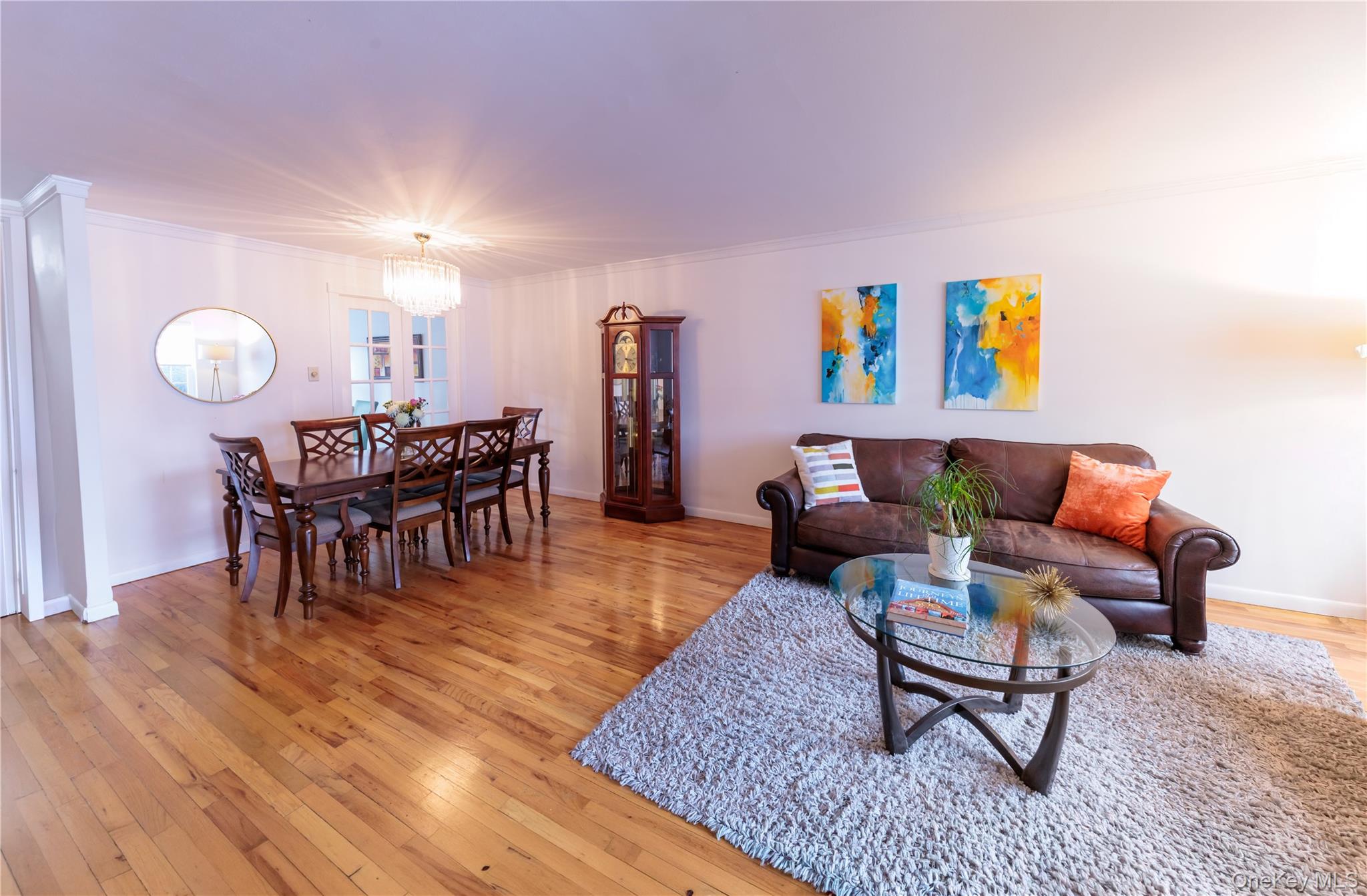 678 Front Street, Unit E Hempstead, NY 11550 - Photo 3 of 22 Living area with light wood-type flooring, ornamental molding, and a chandelier
