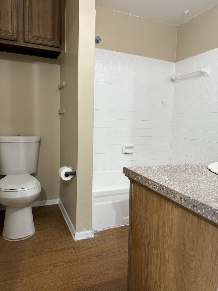 806 West 24th Street, Unit 223 Austin, TX 78705 - Photo 15 of 16 Bathroom with shower / bathing tub combination, wood finished floors, toilet, and baseboards