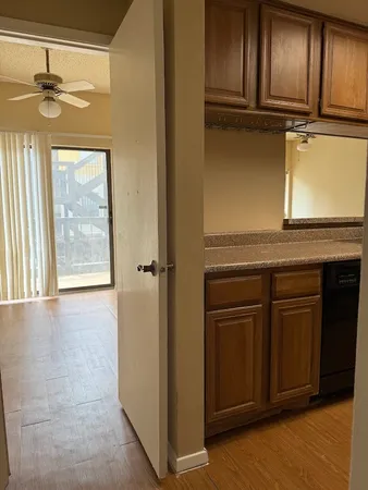 a view of a kitchen with wooden floor and cabinets