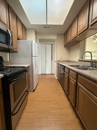 a kitchen with stainless steel appliances granite countertop a stove a sink and a refrigerator