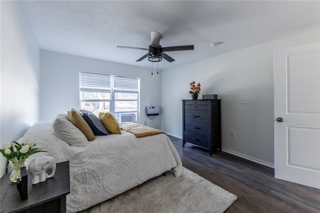 1117 East Sycamore Street Navasota, TX 77868 - Photo 15 of 24 a bedroom with a bed and wooden floor