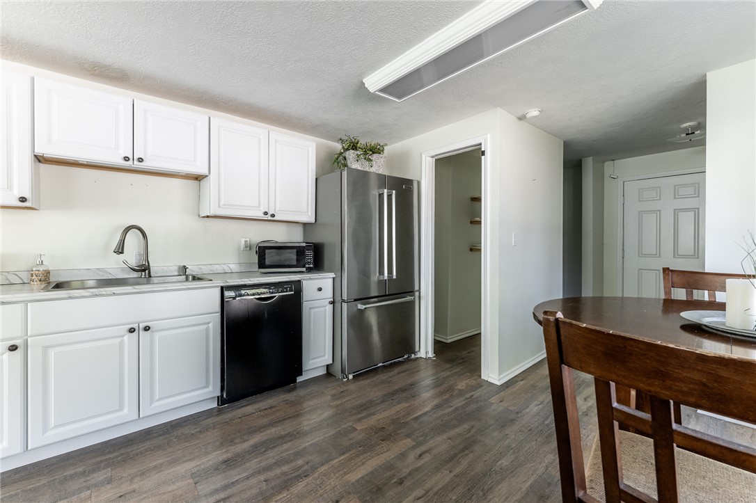1117 East Sycamore Street Navasota, TX 77868 - Photo 6 of 24 a kitchen with a sink cabinets stainless steel appliances and a window