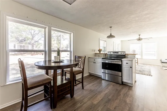 a kitchen with a stove a sink and chairs