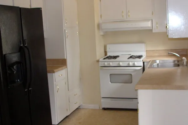 a kitchen with granite countertop white cabinets and white appliances