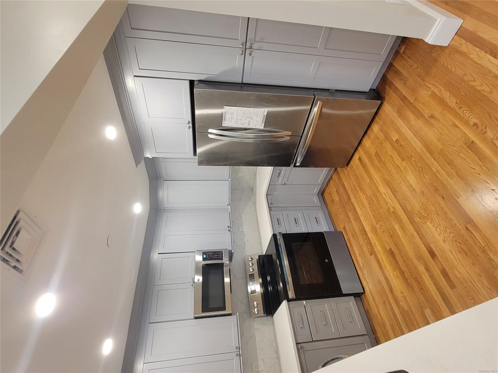 731 Broadway, Unit 3 Valhalla, NY 10595 - Photo 6 of 14 Kitchen featuring gray cabinetry, light hardwood / wood-style flooring, stainless steel fridge, stove, and decorative backsplash