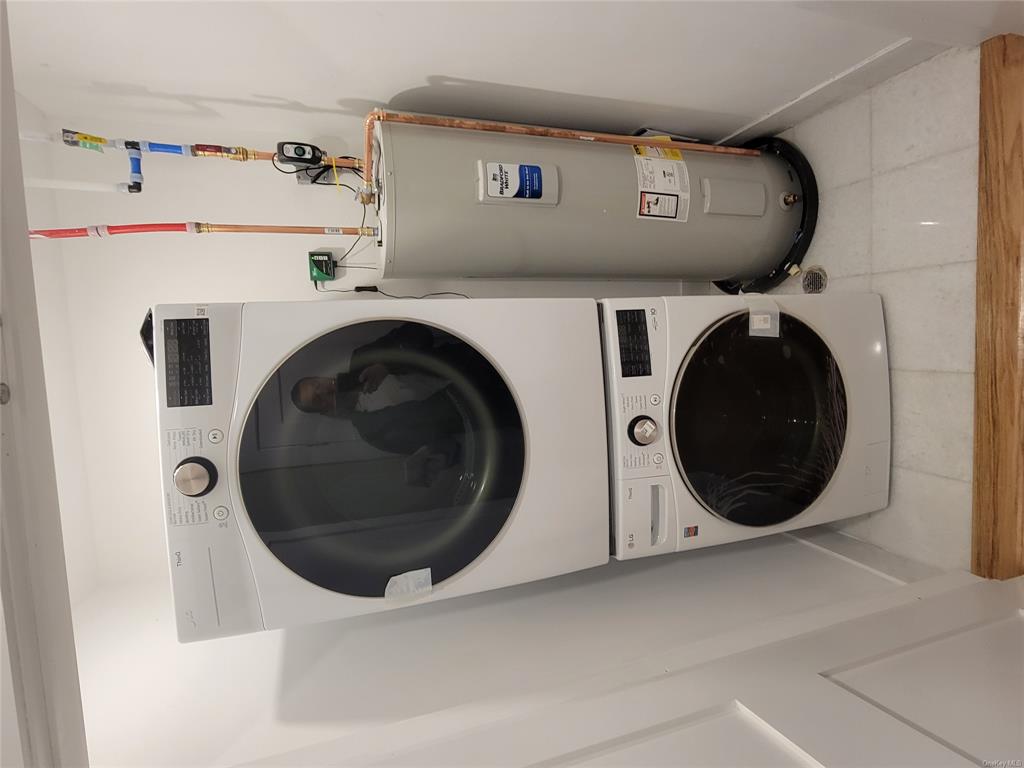 731 Broadway, Unit 3 Valhalla, NY 10595 - Photo 10 of 14 Washroom with water heater, tile patterned flooring, and stacked washing maching and dryer