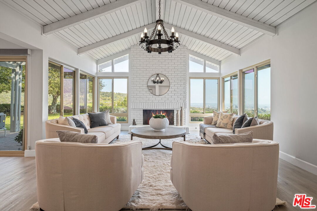 a living room with fireplace furniture and a large window