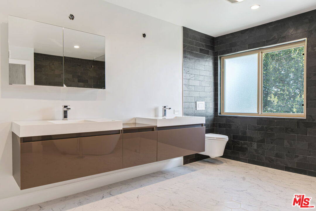 2526 Cordelia Road Los Angeles, CA 90049 - Photo 17 of 35 a spacious bathroom with a double vanity sink a mirror and a bathtub
