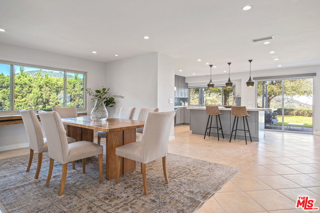 2526 Cordelia Road Los Angeles, CA 90049 - Photo 25 of 35 a dining room with furniture a chandelier and wooden floor