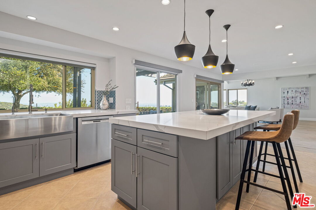 2526 Cordelia Road Los Angeles, CA 90049 - Photo 27 of 35 a kitchen with granite countertop a sink a center island and windows