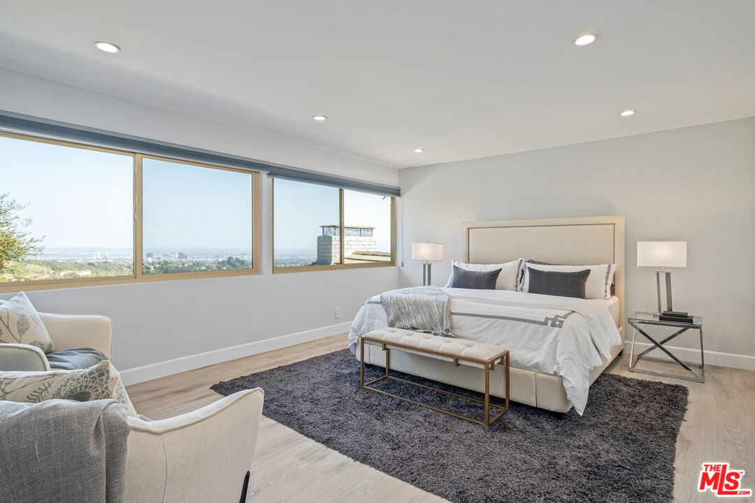 2526 Cordelia Road Los Angeles, CA 90049 - Photo 29 of 35 a spacious bedroom with a bed and a large window