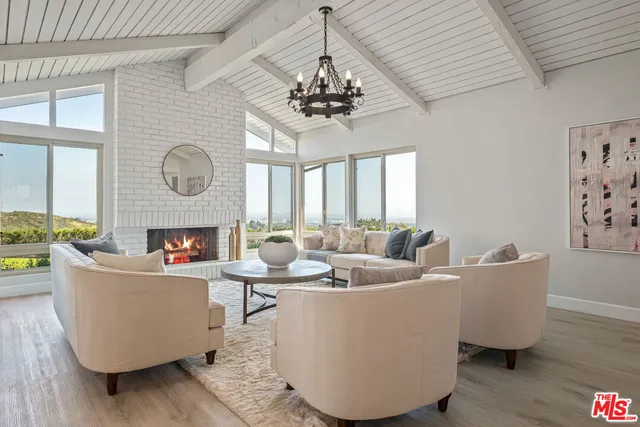a living room with fireplace furniture and a large window