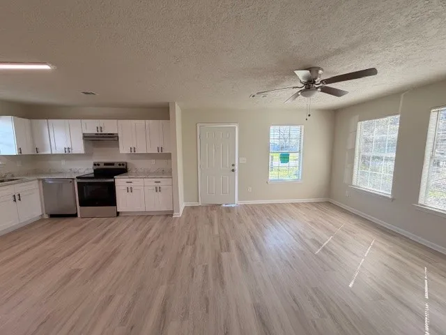 a view of kitchen with granite countertop cabinets and wooden floor