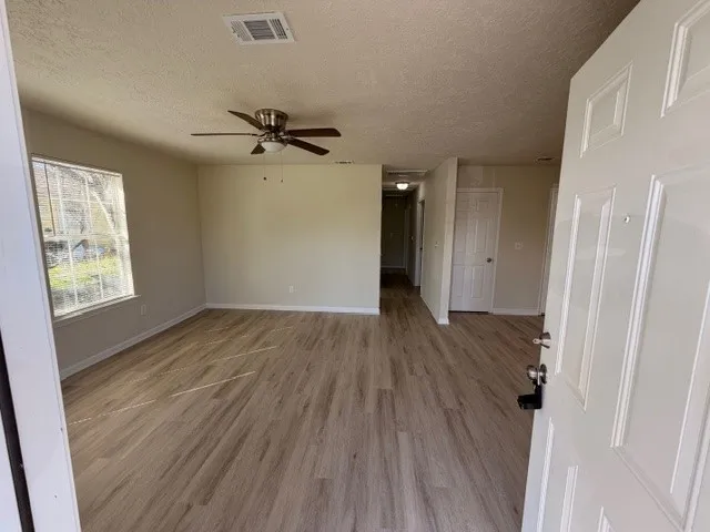 wooden floor in an empty room with a window