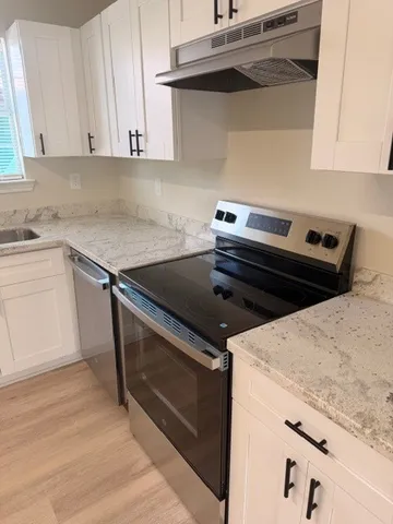 a kitchen with a stove and white cabinets