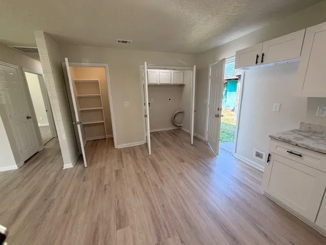 wooden floor in an empty room with a kitchen