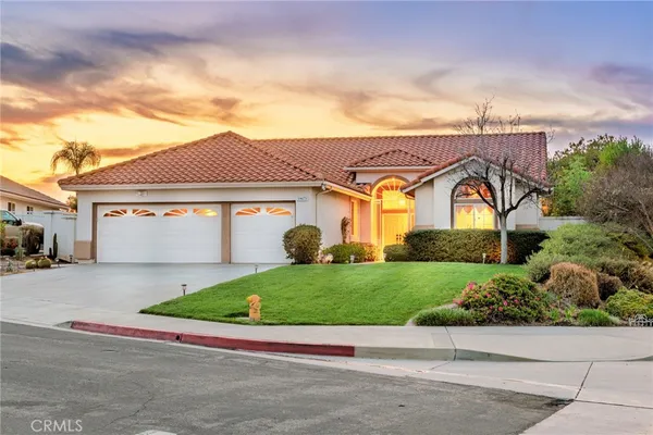 a front view of a house with a garden and garage
