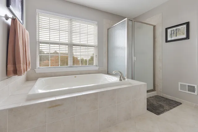a spacious bathroom with bathtub and window