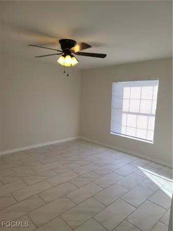 an empty room with windows and fan