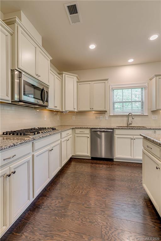 310 Calming Way Tega Cay, SC 29708 - Photo 14 of 48 a kitchen with stainless steel appliances granite countertop a stove a sink and a microwave