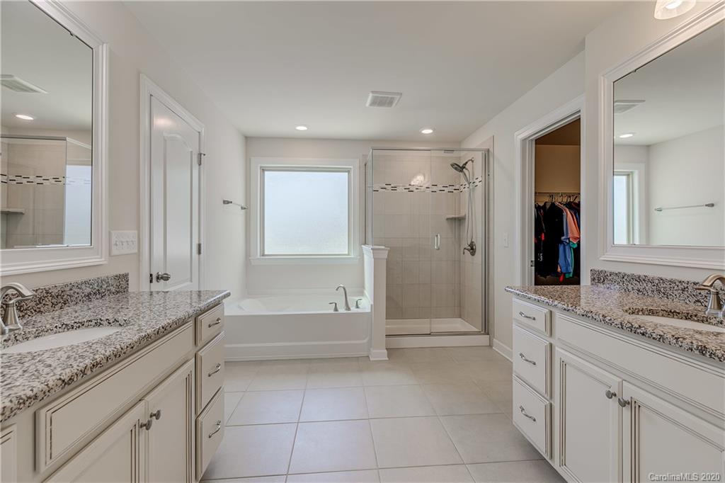 310 Calming Way Tega Cay, SC 29708 - Photo 22 of 48 a bathroom with a granite countertop sink mirror and bathtub