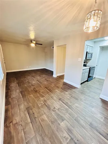 en empty room with wooden floor and fan