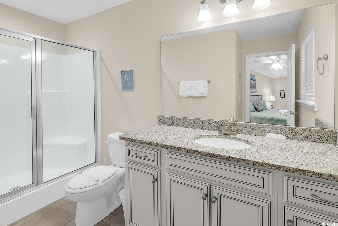 117 B 16th Avenue South Surfside Beach, SC 29575 - Photo 16 of 40 Full bath featuring vanity, connected bathroom, a stall shower, light tile patterned flooring, and a ceiling fan
