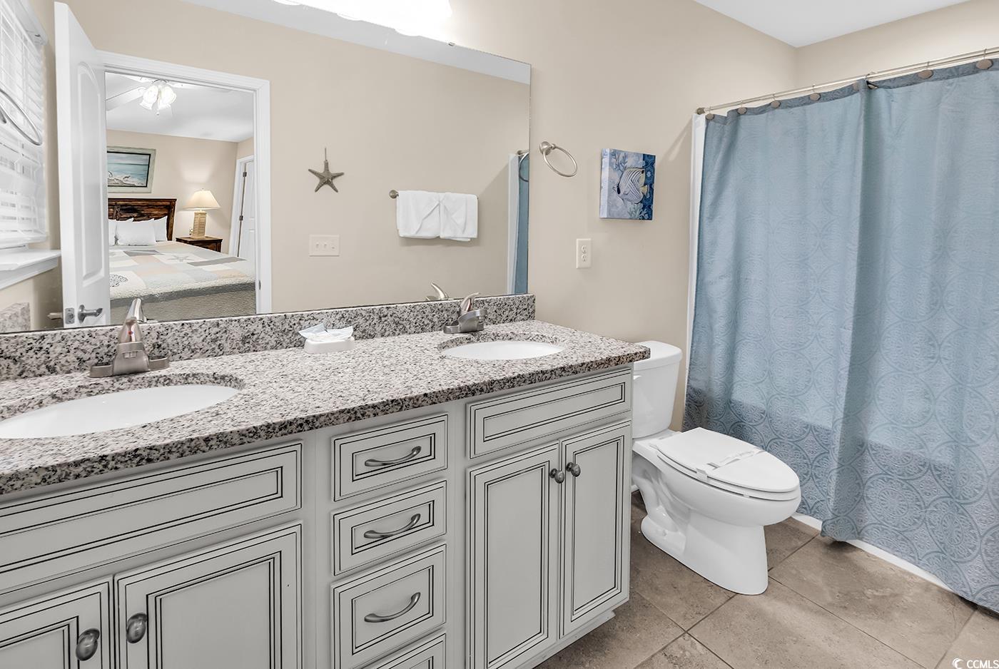 117 B 16th Avenue South Surfside Beach, SC 29575 - Photo 25 of 40 Bathroom featuring ensuite bath, double vanity, light tile patterned floors, and shower / bath combo with shower curtain