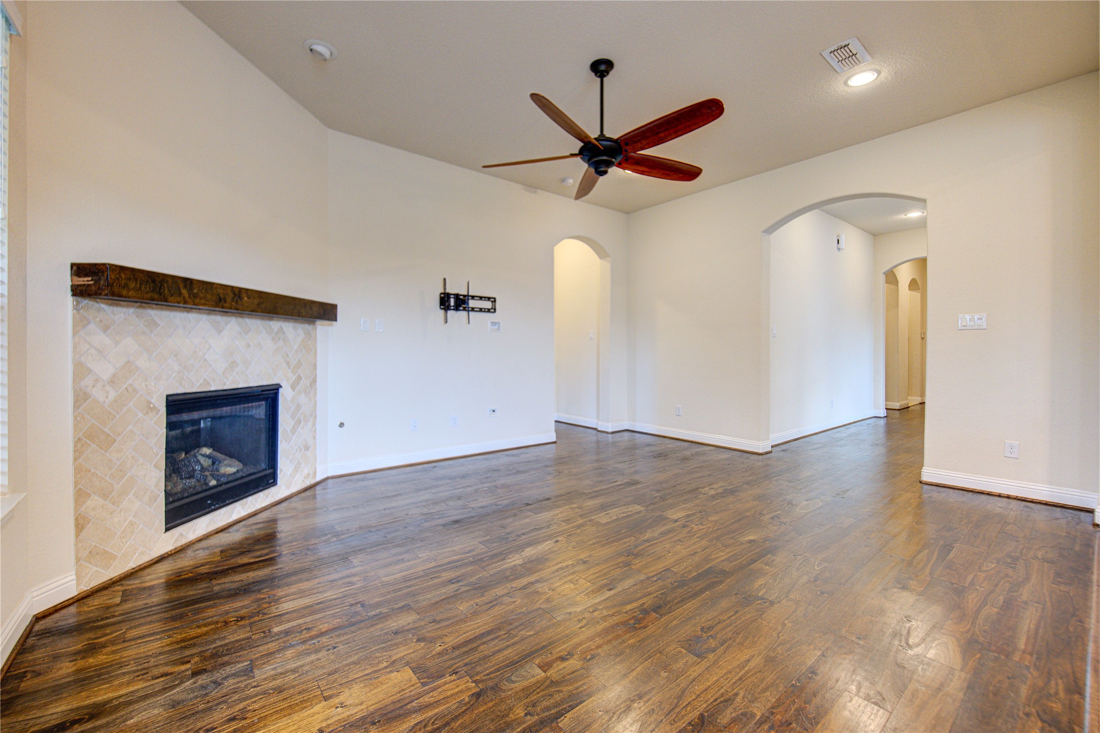 6622 Tiger Trail Katy, TX 77493 - Photo 11 of 49 an empty room with wooden floor a ceiling fan a fireplace and windows