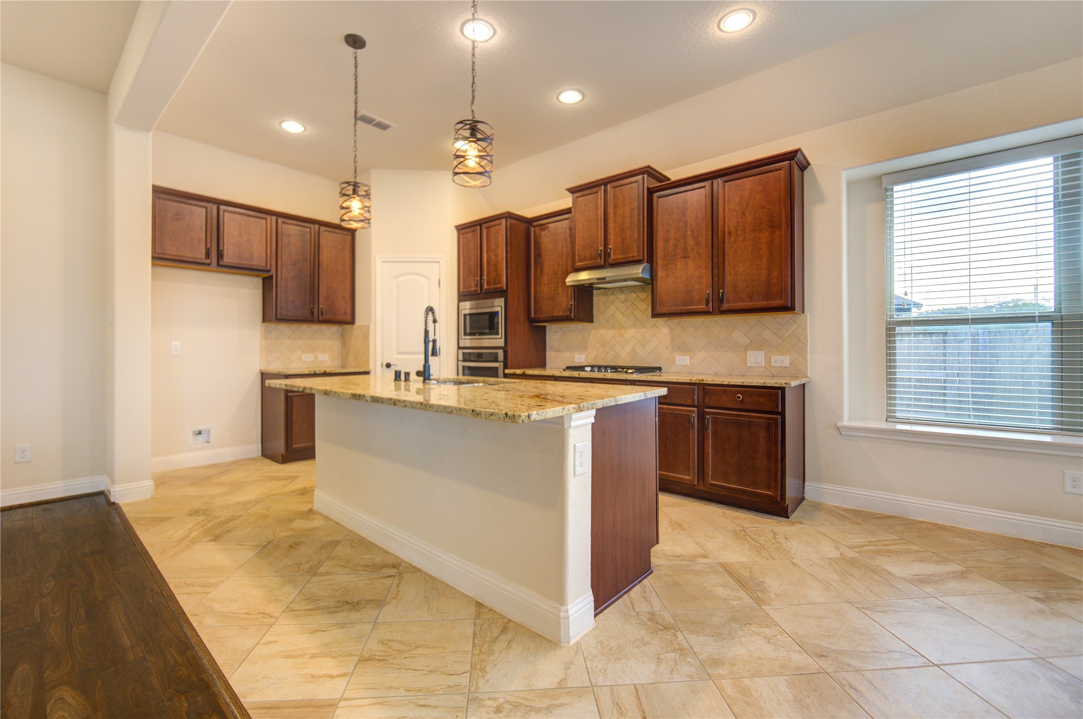 6622 Tiger Trail Katy, TX 77493 - Photo 24 of 49 a large kitchen with stainless steel appliances kitchen island granite countertop a stove top oven a sink a counter space and cabinets