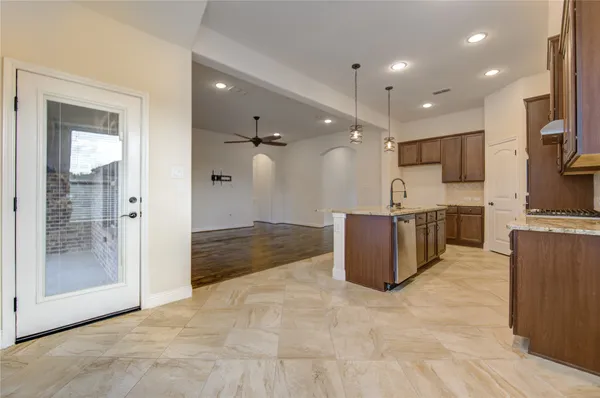 a view of kitchen with stainless steel appliances kitchen island granite countertop a refrigerator and a sink