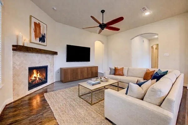 a living room with furniture a flat screen tv and a fireplace