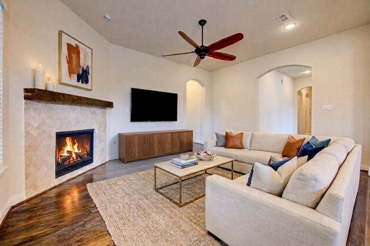 6622 Tiger Trail Katy, TX 77493 - Photo 10 of 49 a living room with furniture a flat screen tv and a fireplace