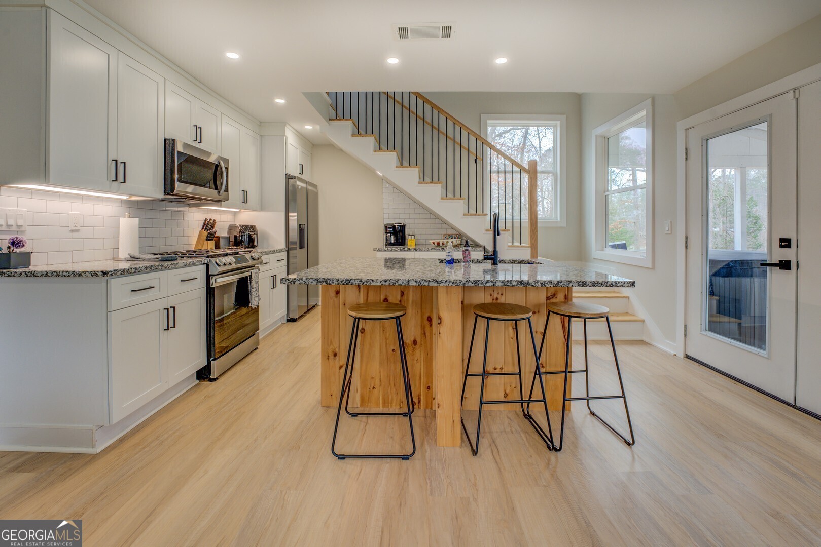 480 Mitchell Road Covington, GA 30014 - Photo 10 of 56 a kitchen with stainless steel appliances kitchen island granite countertop a stove a sink and a refrigerator