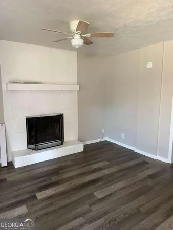 a view of empty room with wooden floor and fireplace
