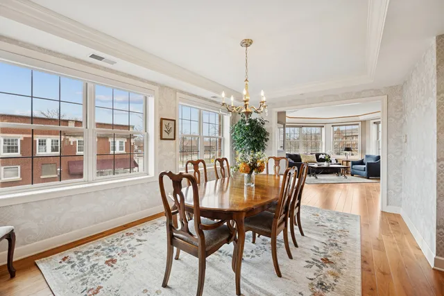 a dining room with furniture a chandelier and wooden floor