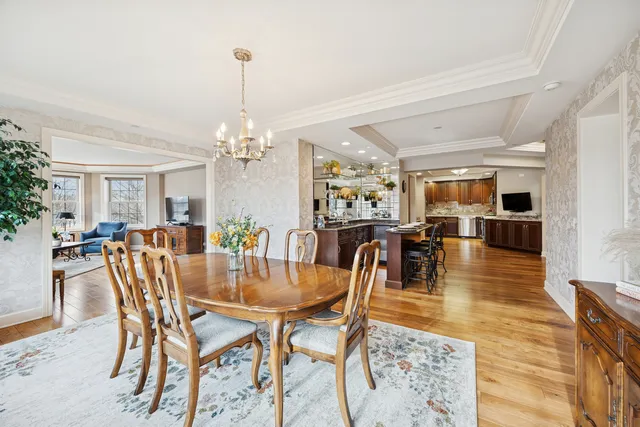 a view of a dining room and livingroom with furniture wooden floor a chandelier