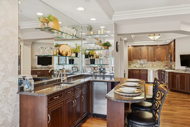 a kitchen with stainless steel appliances granite countertop a sink a stove and a wooden cabinets