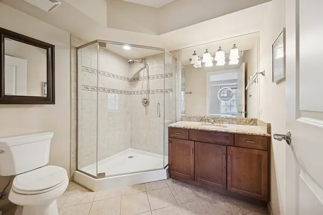 a bathroom with a granite countertop sink toilet and shower