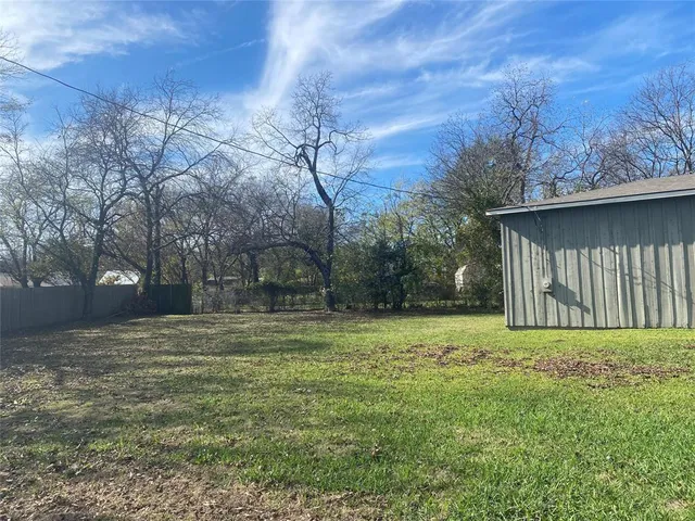 a view of a backyard with large trees